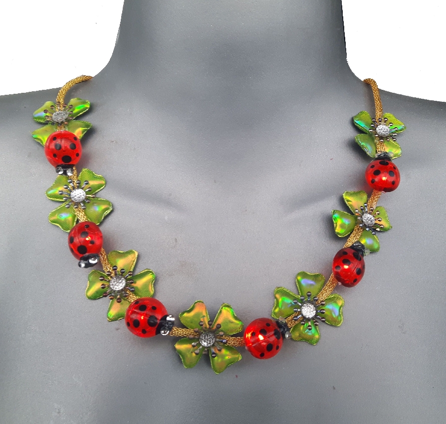 Necklace with red ladybug beads and green leaf-shaped details